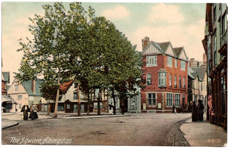 The front of an old postcard. The postcard is of Abingdon: Town Centre Streets
