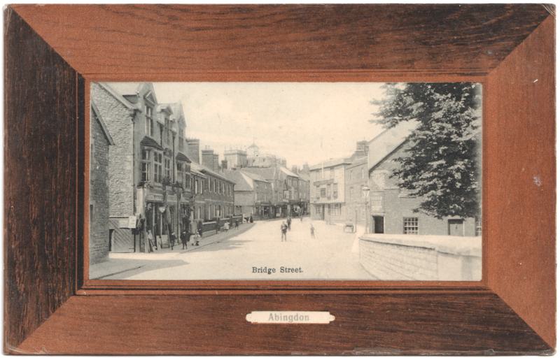 The front of an old postcard. The postcard is of Abingdon: Town Centre Streets