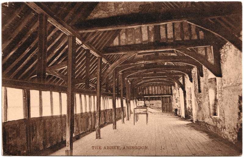 The front of an old postcard. The postcard is of Abingdon: The Abbey Buildings