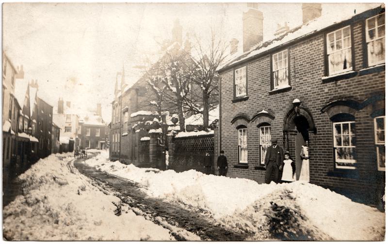 The front of an old postcard. The postcard is of Abingdon: Town Centre Streets